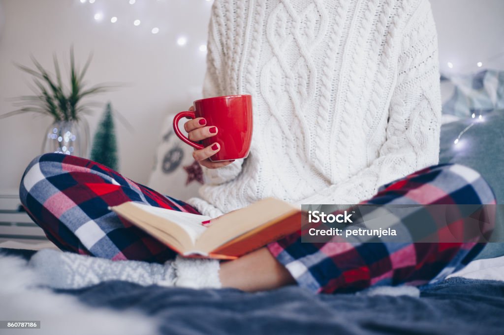 Christmas morning Young women drinking coffee in bed. It is Christmas morning room is decorated Wellbeing Stock Photo