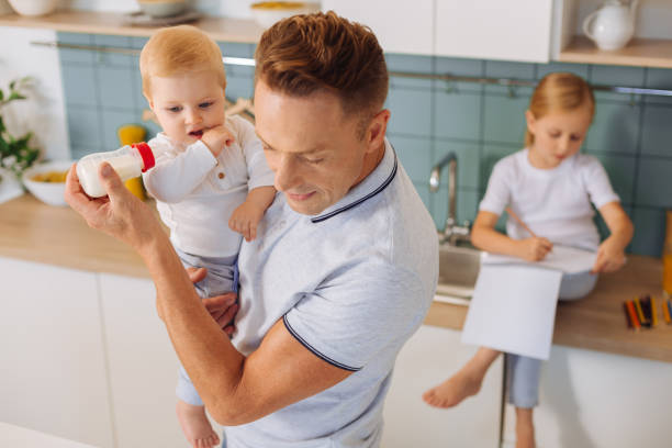 istock Serious smart man feeding his child 860789348