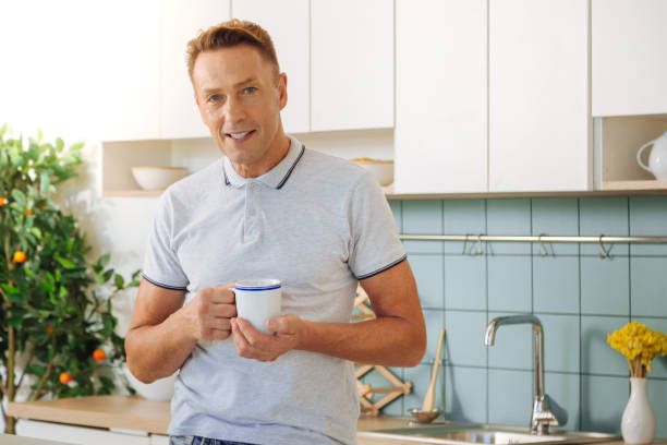 istock Handsome positive man holding a cup with tea 860789930