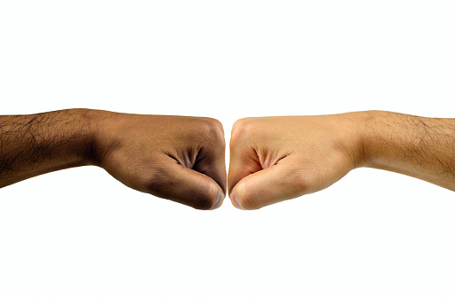 Cropped shot of two unrecognisable people fist bumping each other against a white background