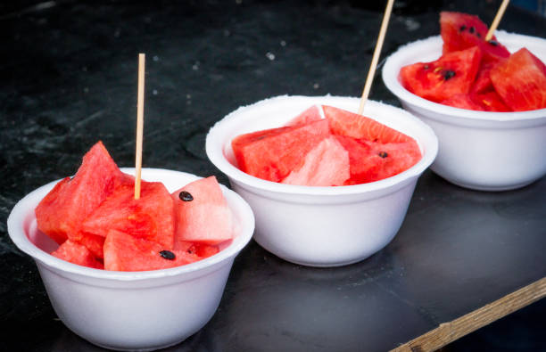 fatia de melancia fresca em recipiente de placa de espuma branca na mesa de madeira preta - watermelon fruit summer portion - fotografias e filmes do acervo