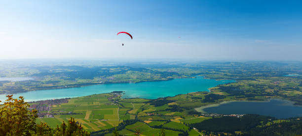 istock Paraglider flies over the green valley 860793562
