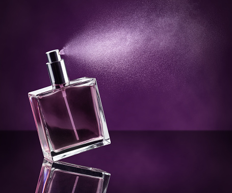 perfume de rociadura sobre fondo púrpura photo
