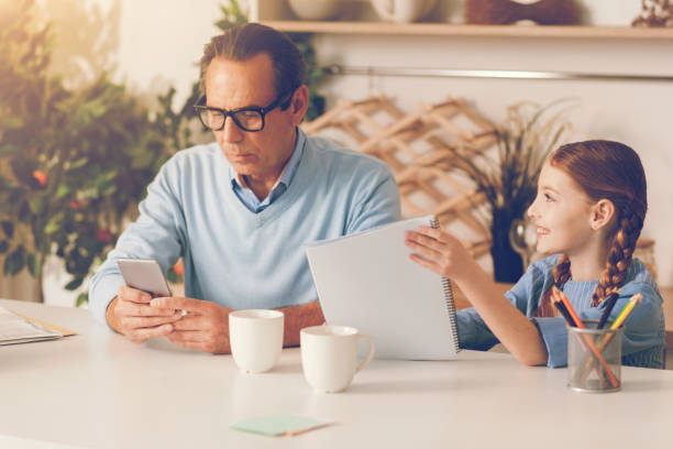 istock Mature father with smartphone ignoring little daughter 860813062