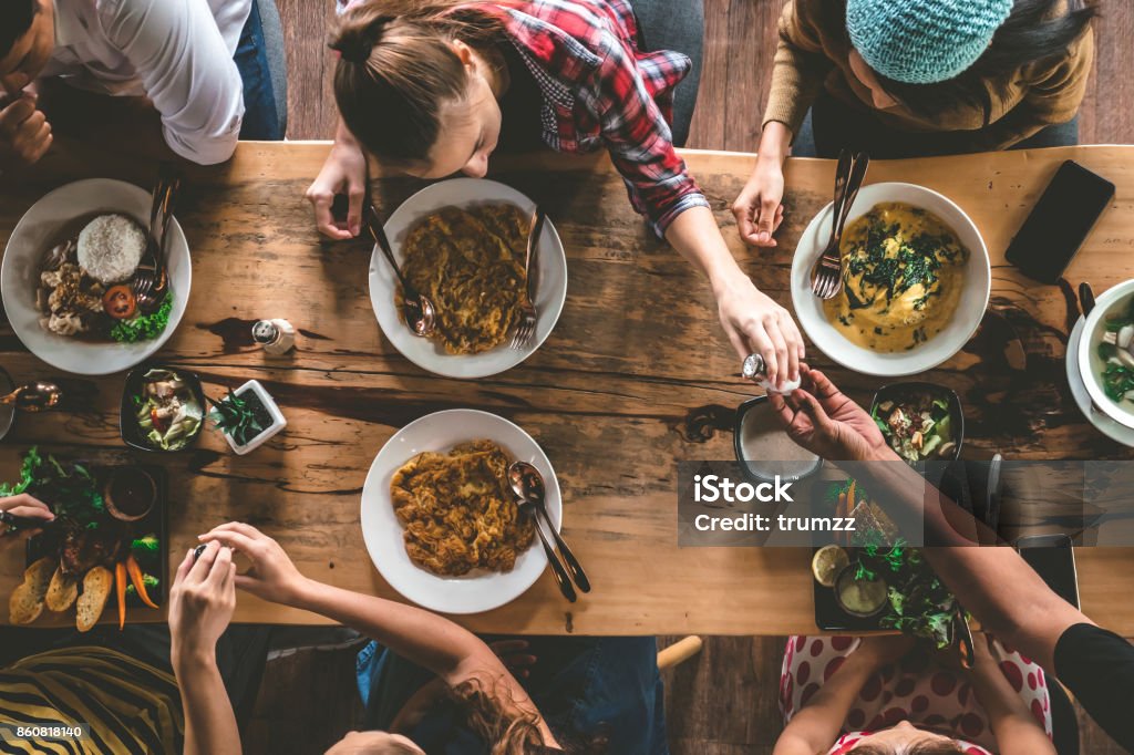 Group of happy friends having nice food and drinks, enjoying the party and communication, Top view of Family gathering together at home for eating dinner. Family Stock Photo