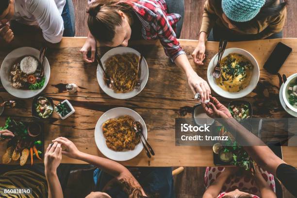 Group Of Happy Friends Having Nice Food And Drinks Enjoying The Party And Communication Top View Of Family Gathering Together At Home For Eating Dinner Stock Photo - Download Image Now