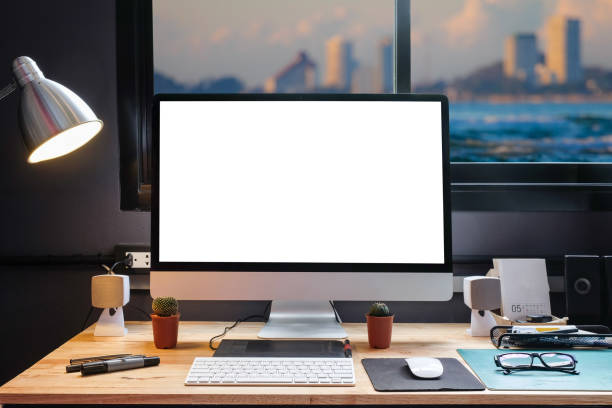 istock Graphic designer's workspace equipped with a pen tablet, a computer and white screen for text with beautiful sunset on the beach from the window 860821806