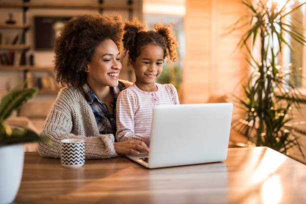 istock Happy black mother and daughter using laptop at home. 860822558