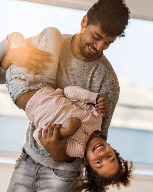 istock Playful African American father having fun with his small daughter. 860826180