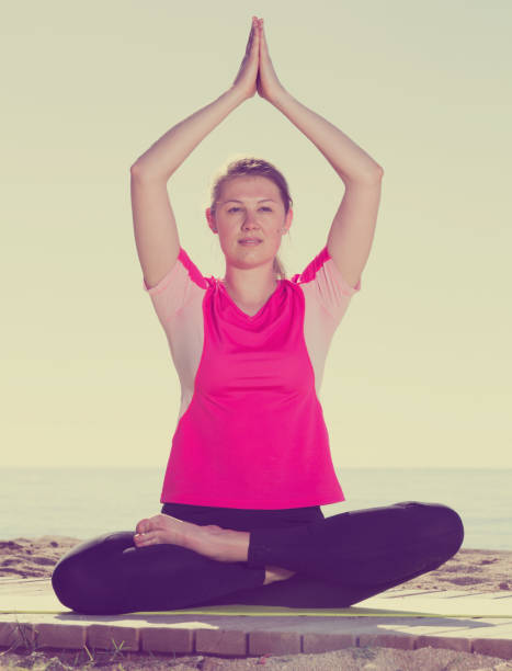 istock Woman exercising yoga poses on beach 860826410