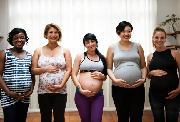 Group of happy pregnant women talking to each other and smiling