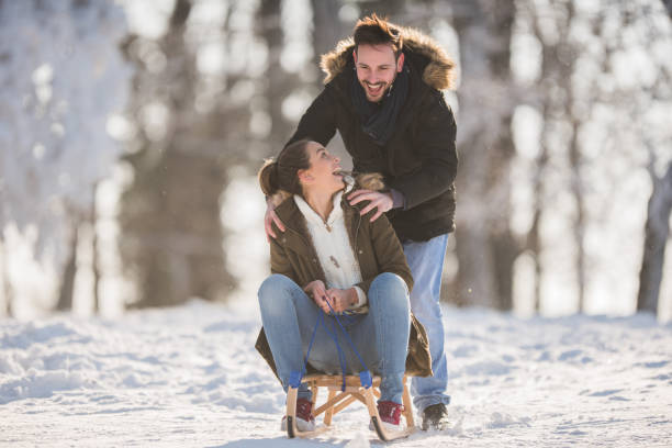 istock Young happy couple having fun on a sledge during cold winter day. 860849432