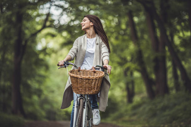 istock Carefree woman riding a bicycle through the forest. 860849916