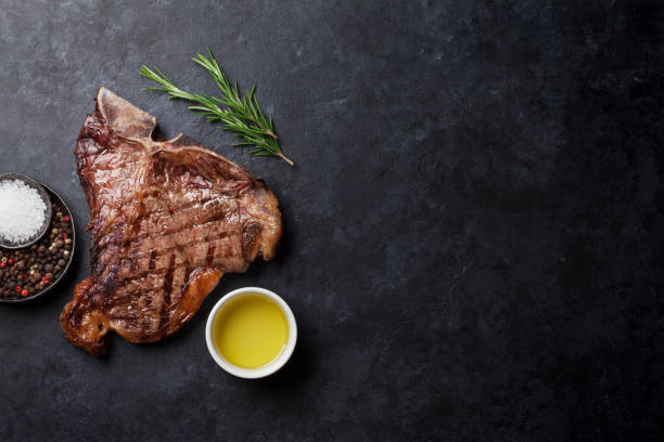 T-bone steak Grilled T-bone steak on stone table. Top view with copy space t bone steak stock pictures, royalty-free photos & images