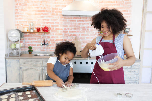 istock Mother and daughter making biscuits at home 860860576