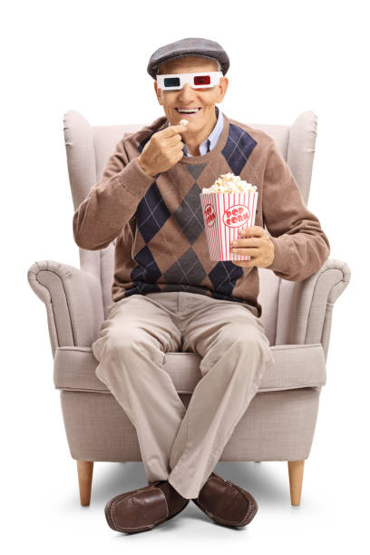 istock Elderly man wearing a pair of 3D glasses and having popcorn 860869016