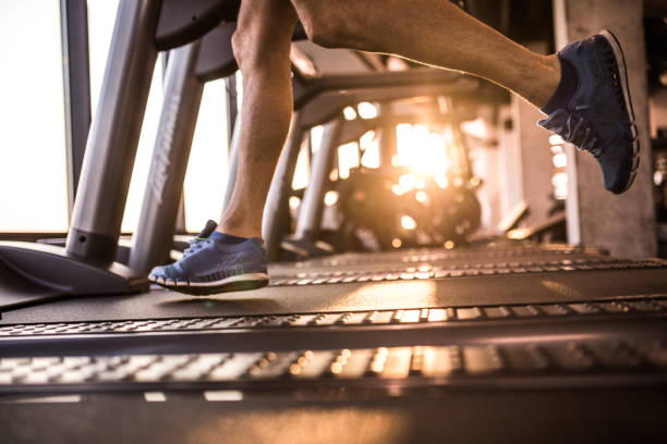 athlète masculin méconnaissable en cours d’exécution sur le tapis roulant dans le club de santé. - treadmill photos et images de collection