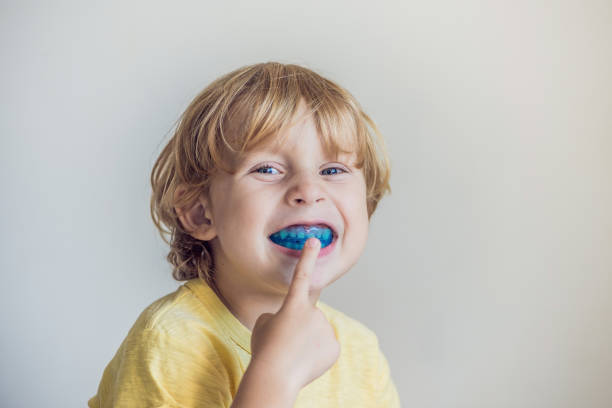 口呼吸の習慣を照らす 3 歳男の子ショー口腔筋機能トレーナー成長の歯の正しい咬合を揃えることができます。舌の位置を修正します。 - マウスピース ストックフォトと画像