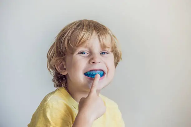 Three-year old boy shows myofunctional trainer to illuminate mouth breathing habit. Helps equalize the growing teeth and correct bite. Corrects the position of the tongue.
