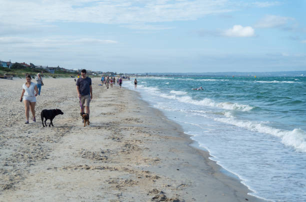 Melbourne, Australia - February 11, 2017: people walking along Aspendale Beach in Melbourne's south eastern suburbs.