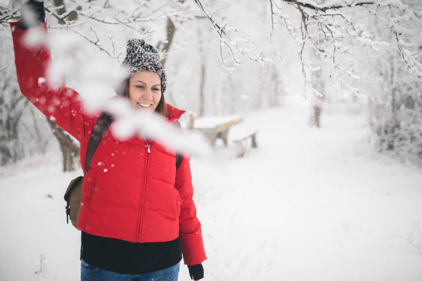 istock Woman with a backpack walking through winter forest. 860873034