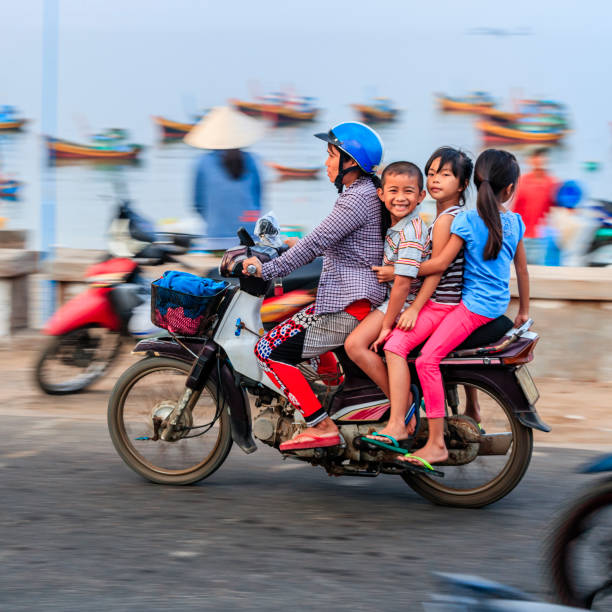 mãe vietnamita com crianças andando de moto, vietnã do sul - blurred motion clothing mother offspring - fotografias e filmes do acervo