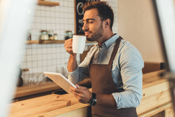 istock barista with cup of coffee using tablet 860880656