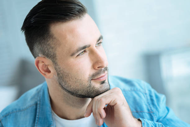 istock Pensive young man resting his chin on hand while thinking 860881204