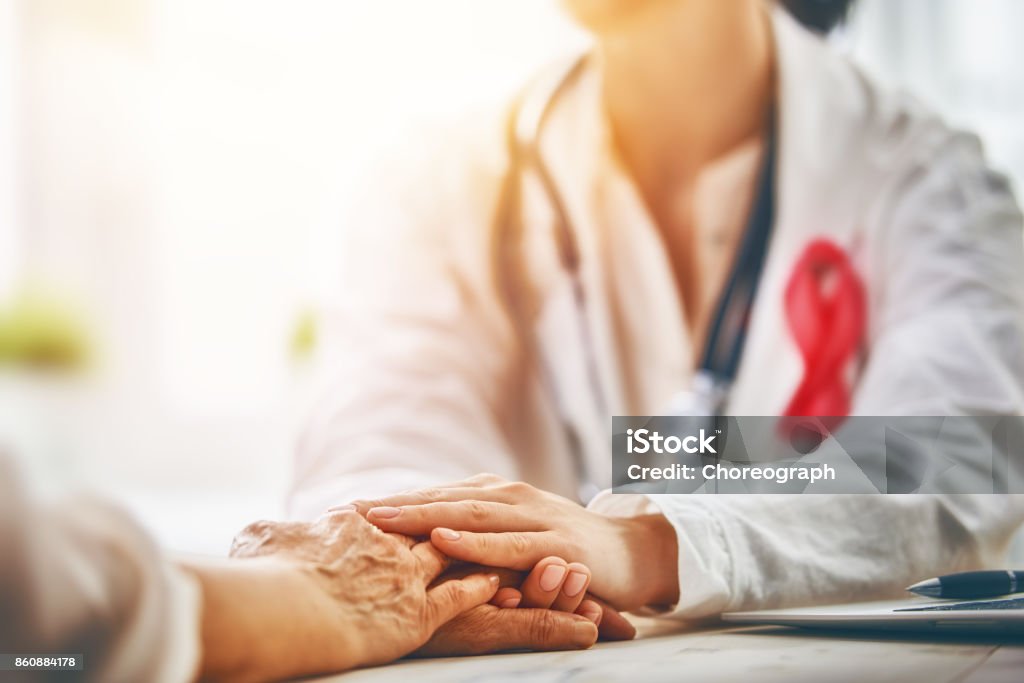 Pink ribbon concept Pink ribbon for breast cancer awareness. Female patient listening to doctor in medical office. Support people living with tumor illness. Cancer - Illness Stock Photo