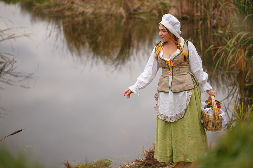 the peasant woman with a basket walks by the river