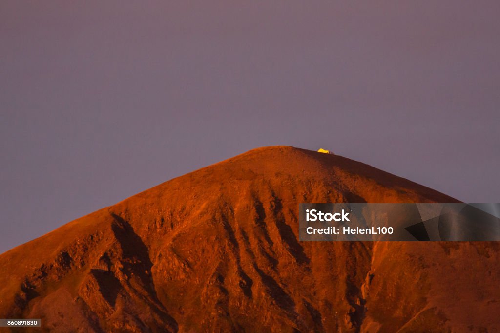 Sunrise reflected onto chapel on top of Croagh Patrick Sunrise light reflected on Croagh Patrick mountain, turning it golden red. Chapel clearly visible at the top. Croagh Patrick Stock Photo