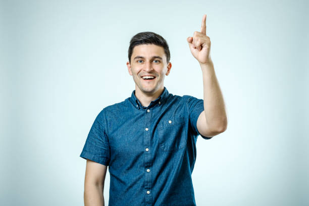 istock Handsome smiling bearded man pointing away on gray background 860892006