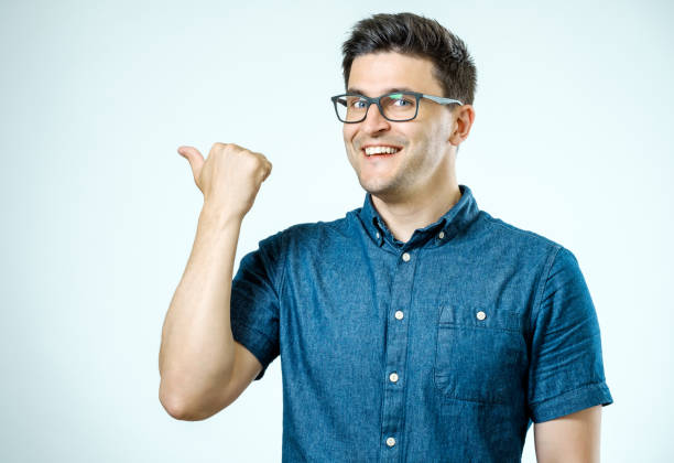 istock Handsome smiling bearded man pointing away on gray background 860892192