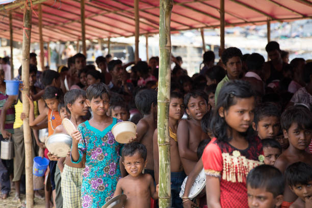 Rohingya childrens waiting for food in refugee camp in Bangladesh Rohingya children waiting for food in refugee camp in Bangladesh. Food is distributed by Turkish NGO. refugee camp stock pictures, royalty-free photos & images