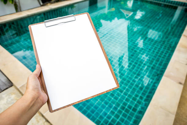istock Blank white paper on clipboard over clear water swimming pool 860897584