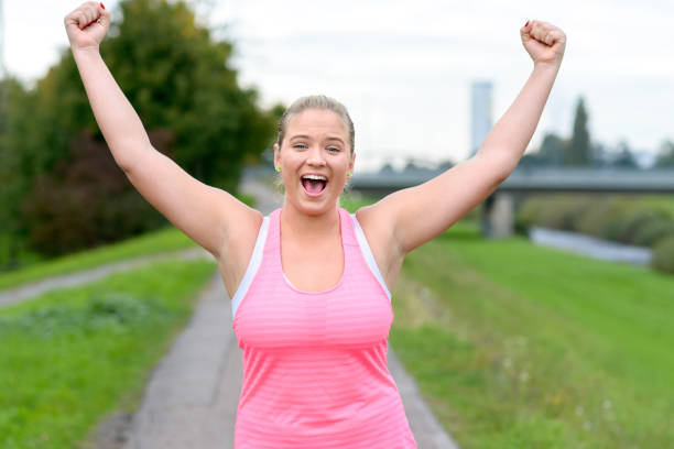 istock Young cheerful woman raising hands while running 860907434