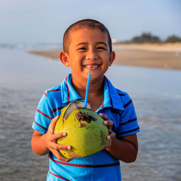 istock Vietnamese boy holding coconut on the beach, Vietnam 860908366