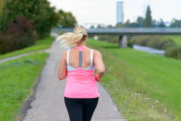istock Blonde woman running along river 860910632