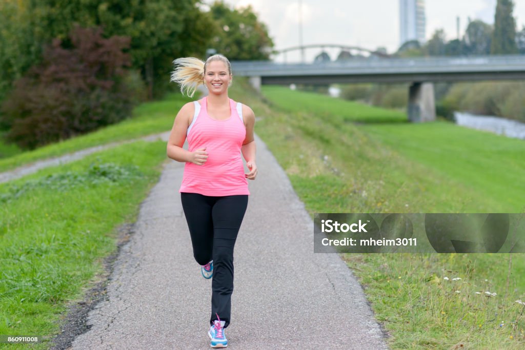 Mujer sonriente rubia a lo largo del río - Foto de stock de Mujeres libre de derechos