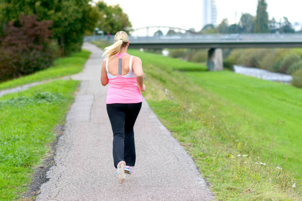 istock Blonde woman running along river 860911098