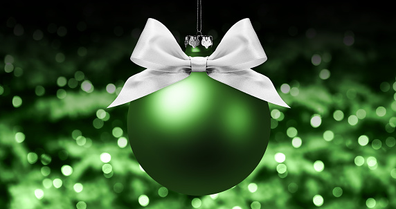 christmas ball, silver satin ribbon bow on blurred green bright lights background