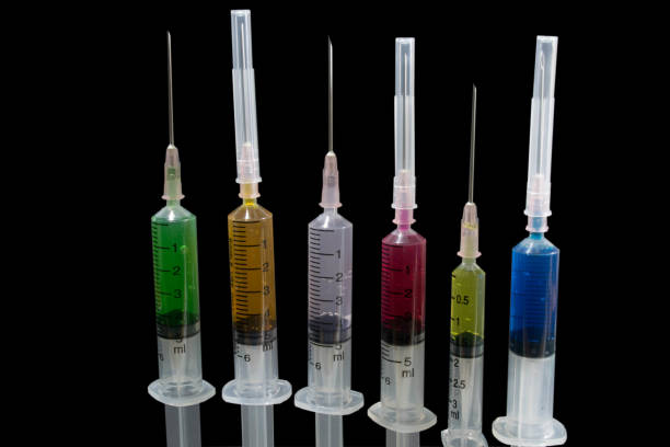 istock Closeup Many multicolor syringes on black background 860918930