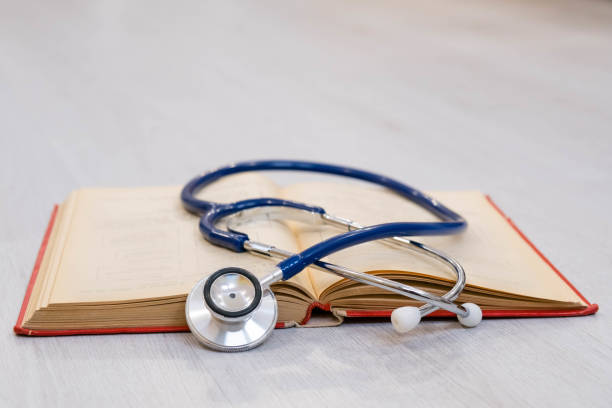 istock Beautiful stethoscope lying on a reference books. Stethoscope with open book on wooden background. Medical literature concept. copy space for text, selective focus 860919002