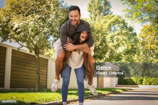 Young Couple Have Fun At City Park Stock Photo - Download Image Now - Adult, Adults Only, Carrying