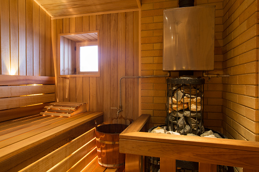 interior de relax sauna con madera con ventana, calentador y piedras photo