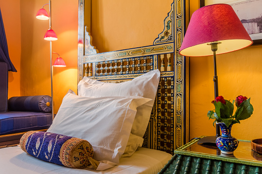 Moroccan hotel bedroom with carved bedhead