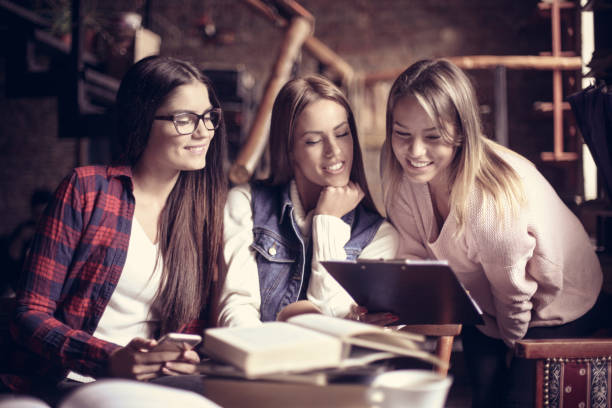 istock Young students girls in cafe learning together. 860930464