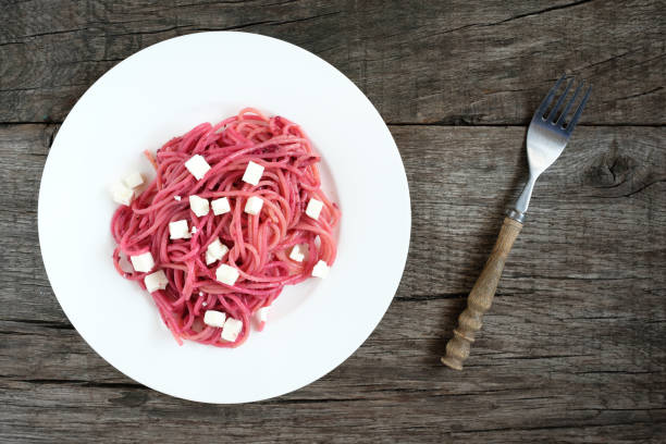 Spaghetti with red beet pesto and sheep cheese on a plate
