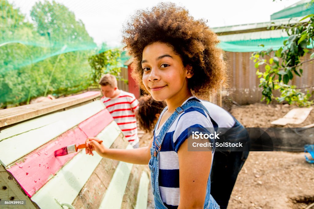 Painting at the Farm A young girl helps paint the chicken coop at the farm. Child Stock Photo