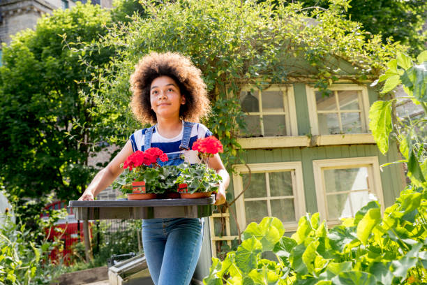 istock Girl Carrying Flowerpots 860940138
